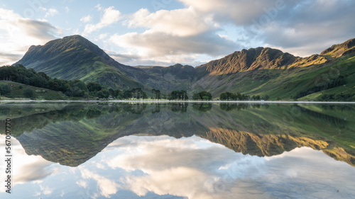 Photography Buttermere in the Lake District with trees and mountains in reflection, beautifu