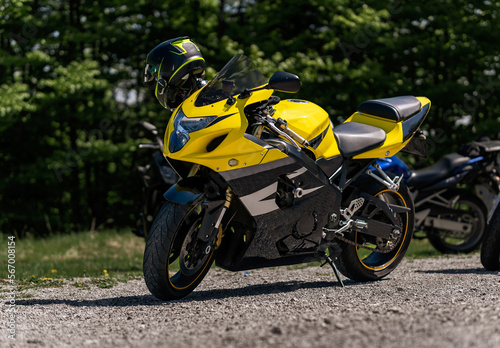 Yellow sportbike motorcycle with helmet on the parking in mountains photo