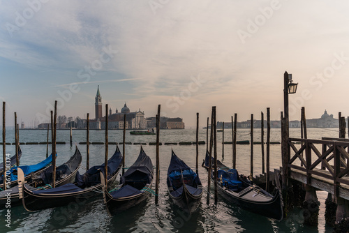 Gondolas docked by the lagoon in Venice, Italy and Saint Giorgio Maggiore in the background © gammaphotostudio