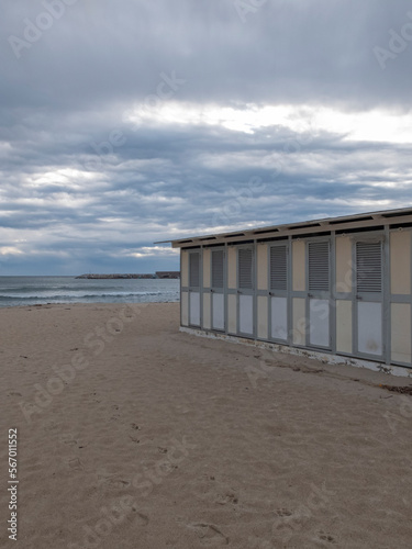 Deserted Italian beach, no one around, we are towards evening with a cloudy sky. It seems that the sand is cold.