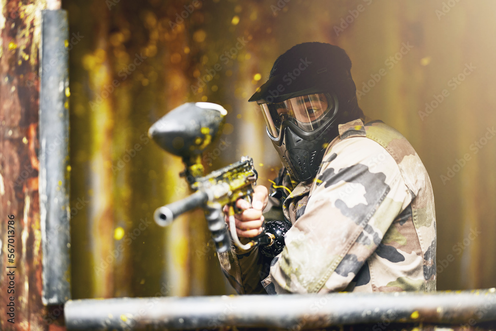 Fototapeta premium Paintball, war and camouflage with a sports man playing a military game for fun or training outdoor. Gun, soldier and target with a male athlete shooting a weapon outside during an army exercise