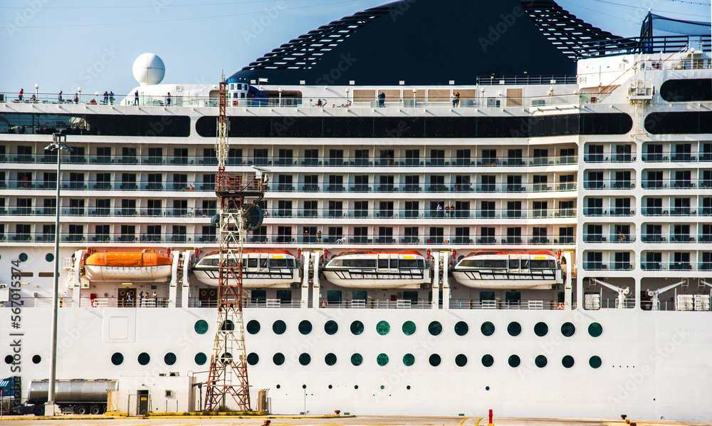 The facade of a modern cruise ship with lifeboats.