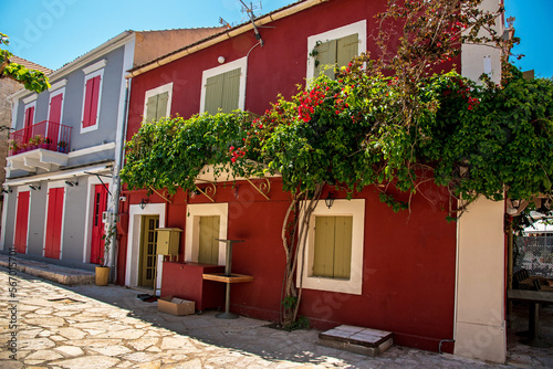 Obraz na płótnie Beautiful atmospheric street view facade with flower pots in the port town of Fiskardo, Kefalonia, Greece. Stunning amazing charming places. prominent tourist towns. w salonie