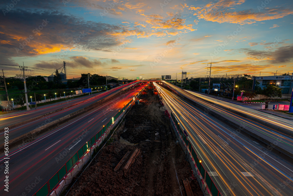 Road and urban transport and evening sky,Traffic speed at dramatic sunset - light trails on motorway highway at night long exposure abstract city background.