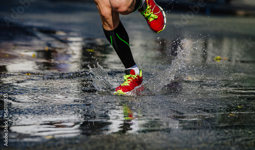 runner legs in compression socks run a puddle, splashing water