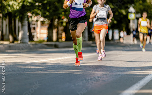 female athlete in compression socks running marathon race