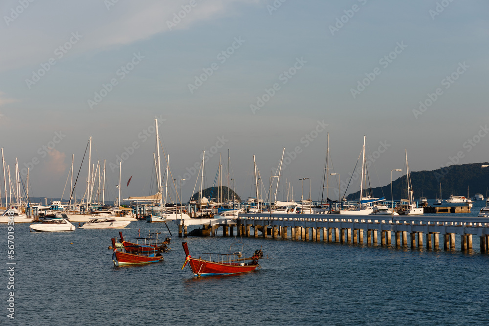 Fototapeta premium Beautiful wooden boats stand in the port against the background of white yachts