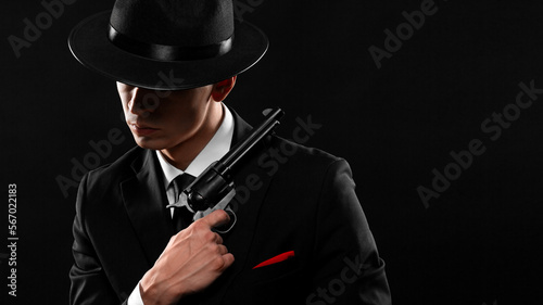 Stylish portrait of gangster from 1940s with a gun.