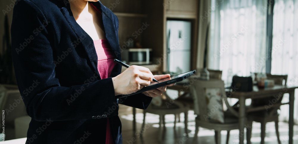 Mature businessman using a digital tablet to discuss information with a younger colleague in a modern business lounge