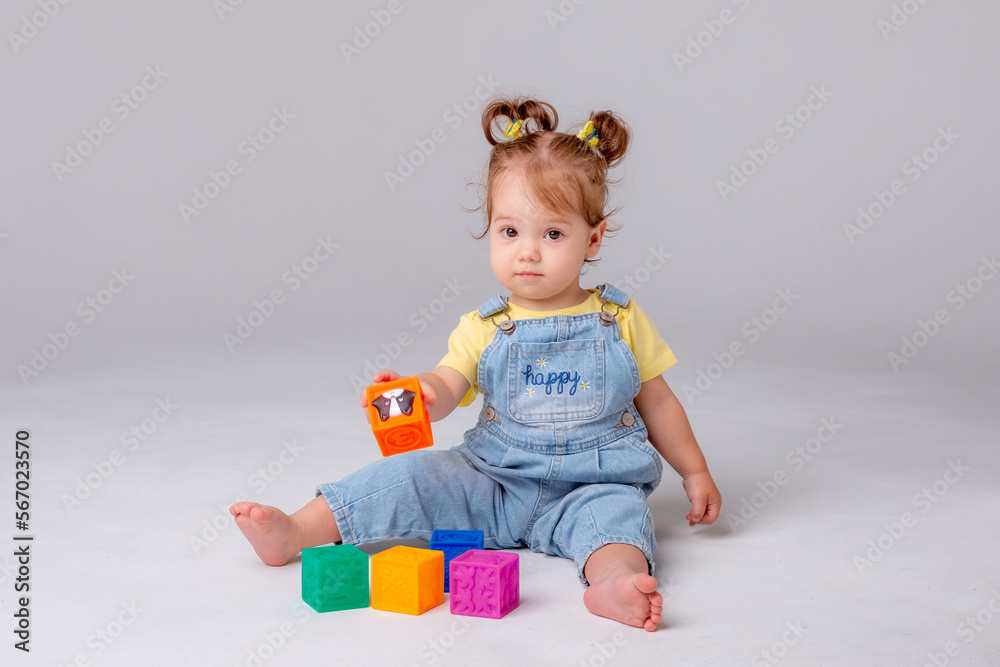 little baby girl is sitting on a white background and playing with colorful cubes. kid's play toy cubes
little baby girl is sitting on a white background and playing with colorful cubes. kid's play toy cubes