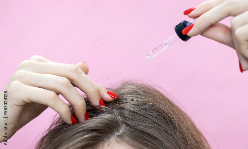 Fototapeta premium face hair care woman apply with pipette serum oil on roots,hand in surgical glove holding split ends.syringe in front of forehead anti aging wrinkle treatment.small scissors cutting hair or white comb
