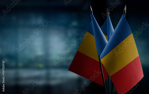 Small flags of the Chad on an abstract blurry background