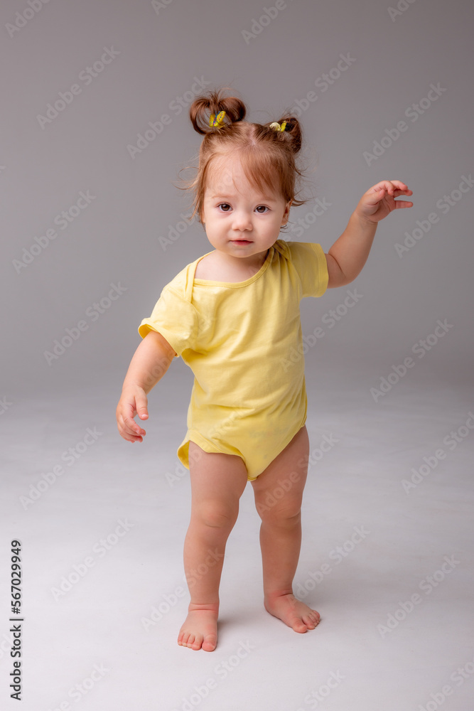 baby girl starting to walk takes her first steps on a white background baby girl starting to walk takes her first steps on a white background