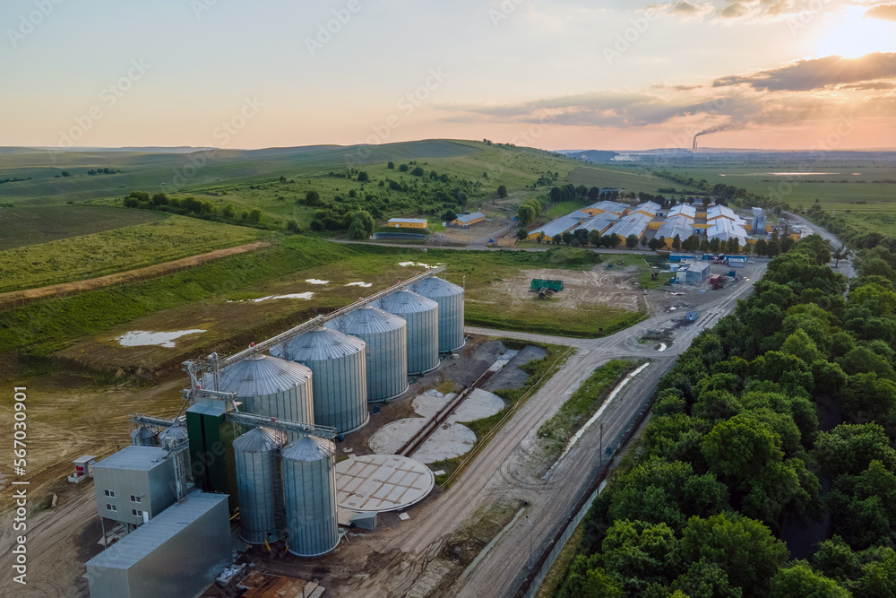 Aerial view of industrial ventilated silos for long term storage of grain and oilseed. Metal elevator for wheat drying in agricultural zone Aerial view of industrial ventilated silos for long term storage of grain and oilseed. Metal elevator for wheat drying in agricultural zone