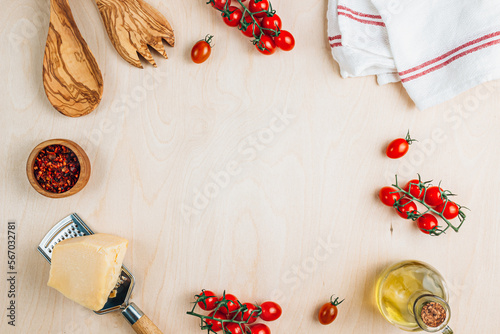 Food cooking background. Food frame on wooden table. Fresh tomato, spices, cheese and oil. Ingredients for cooking with space for your text.