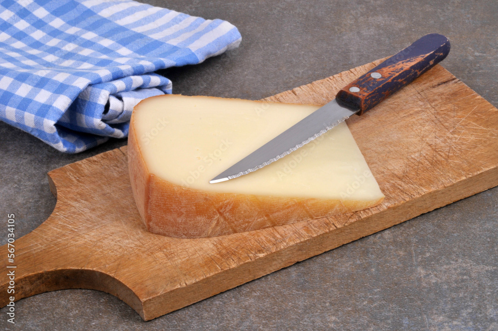 Fromage de brebis basque sur une planche à découper avec un couteau en gros plan