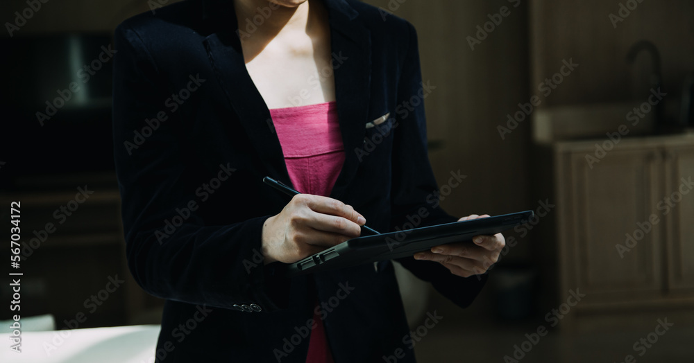 Mature businessman using a digital tablet to discuss information with a younger colleague in a modern business lounge