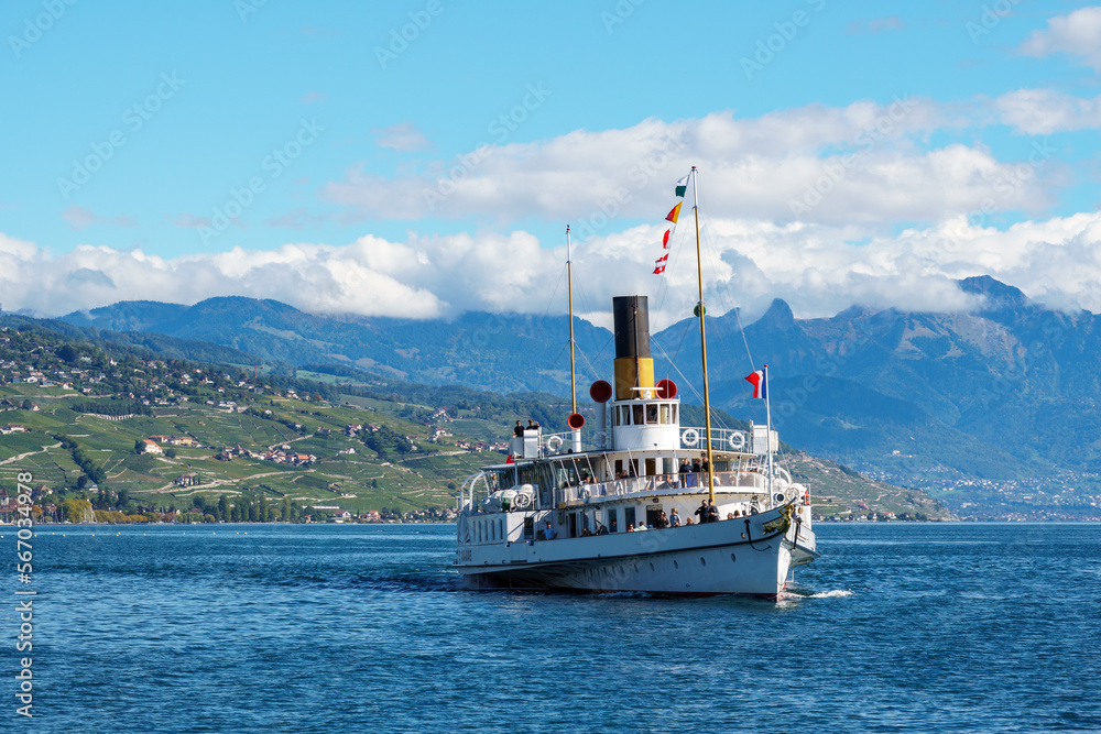 Steamboat on lake geneva sailing in front of terraced hills Steamboat on lake geneva sailing in front of terraced hills