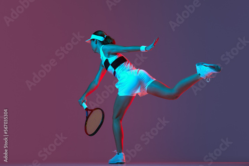 Fototapeta Naklejka Na Ścianę i Meble -  Back view of professional tennis player playing tennis over pink-purple background in neon light. Concept of sport, health, strength, action, motion, lifestyle.