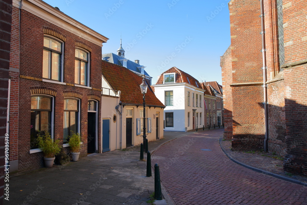 The historic city center of Weesp, a small town located in the East of Amsterdam, North Holland, Netherlands, with historic houses along Kerkstraat street and with St Laurenskerk church on the right