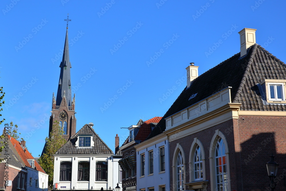 Obraz premium The historic city center of Weesp, a small town located in the East of Amsterdam, North Holland, Netherlands, with historic houses along Nieuwstraat street and Saint Lawrence (Laurentius) church