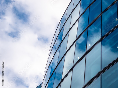London UK - Close up of Business Financial district office headquarters within the modern skyscrapers. Blue clean modern glass wall with sky and cloud reflection. Capital city commercial district