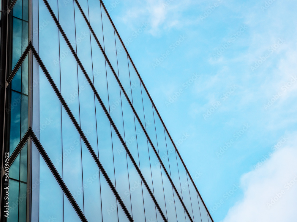 London UK - Close up of Business Financial district office headquarters within the modern skyscrapers. Blue clean modern glass wall with sky and cloud reflection. Capital city commercial district