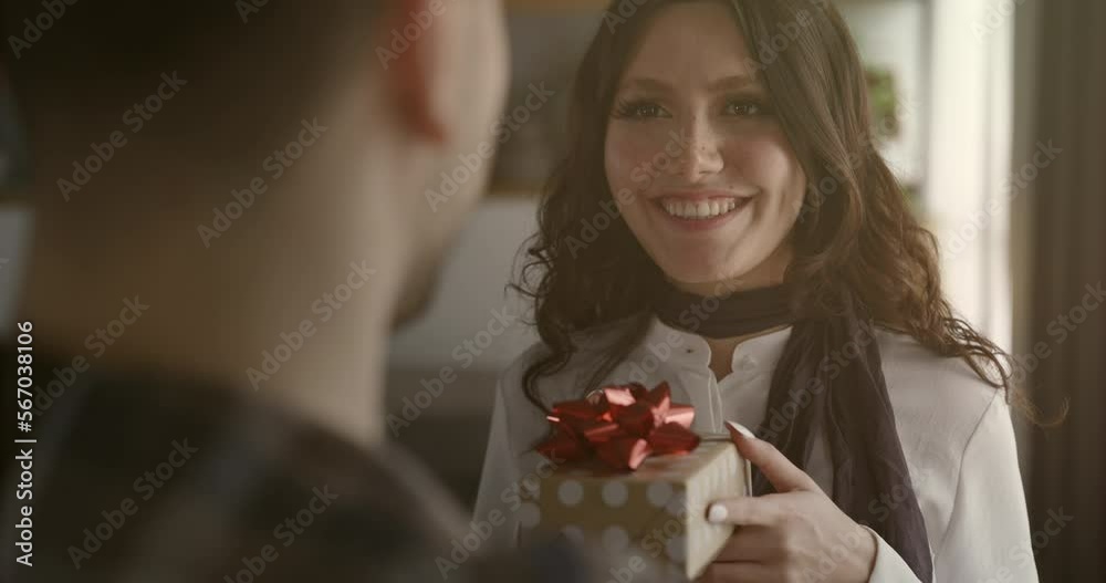 Young man giving gift to young woman