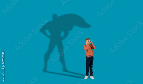 Shadow of super hero over dreamy ginger guy schooler photo