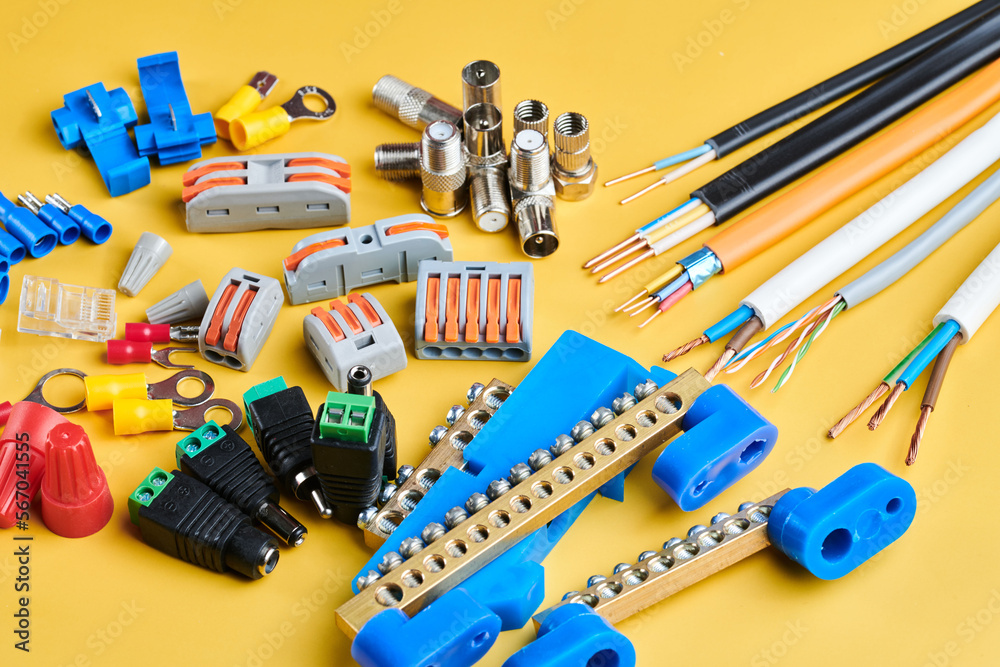 Obraz premium Different electrical tools isolated on yellow background, electrician equipment, wires, terminals, connectors, fuses, switches