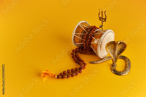 Shivaratri background with Shivas trident, Pellet Drum Damroo musical instrument ans snake . Maha Shivratri festval photo