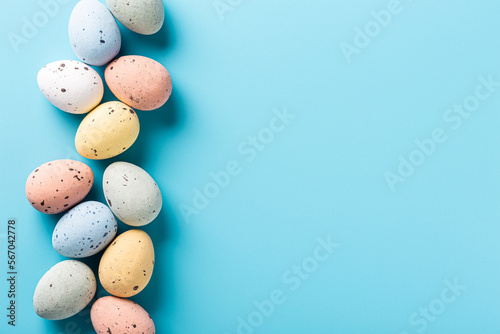 Easter quail eggs over blue background. Spring holidays concept with copy space. Top view