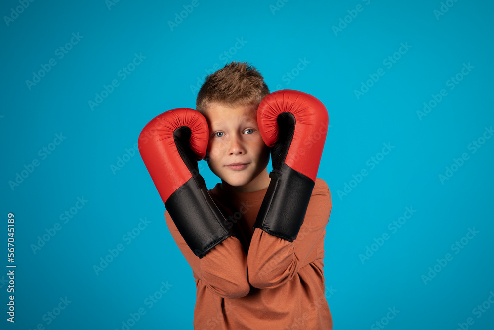 Portrait Of Preteen Blonde Boy Covering Ears With Boxing Gloves Portrait Of Preteen Blonde Boy Covering Ears With Boxing Gloves