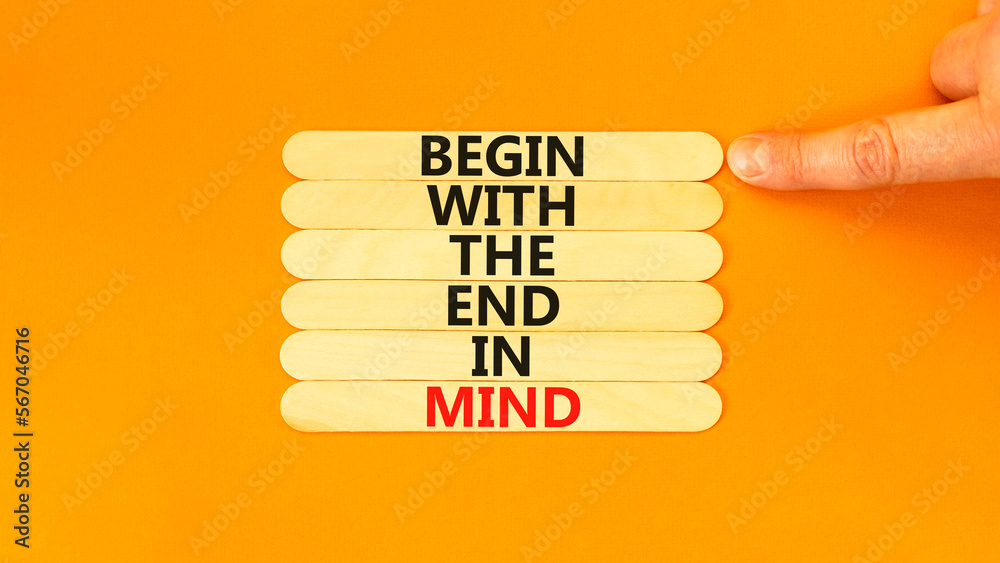Begin in end of mind symbol. Concept words Begin with the end in mind on wooden stick. Beautiful orange table orange background. Businessman hand. Business begin in end of mind concept. Copy space. Begin in end of mind symbol. Concept words Begin with the end in mind on wooden stick. Beautiful orange table orange background. Businessman hand. Business begin in end of mind concept. Copy space.