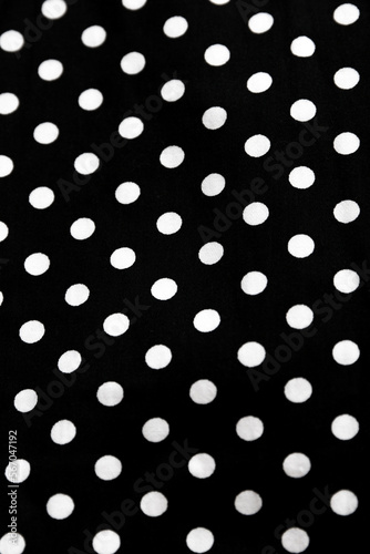 Polka dot patterned black and white fabric textile folded cloths as background