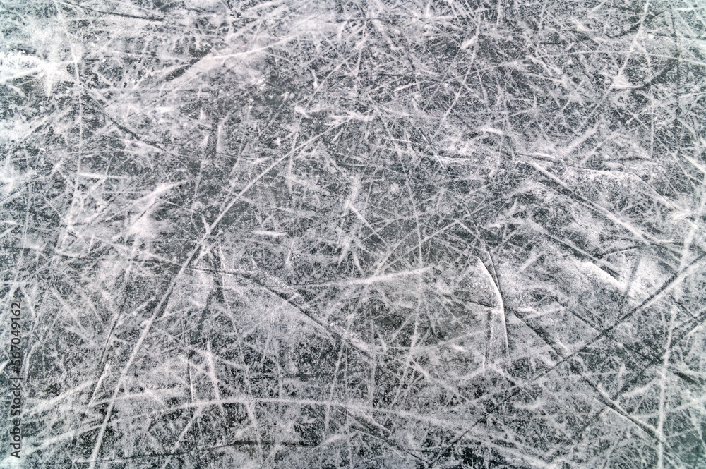 The ice on which there is some snow on the hockey field is cut by hockey players' skates