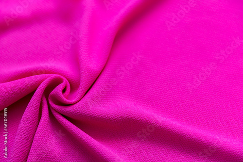 Bright pink magenta folded fabric textile as texture background