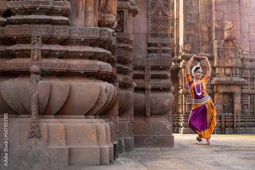 Indian classical dancer in traditional dress and posing in front of temple. Classical indian temple dance form Odissi. Dance pose