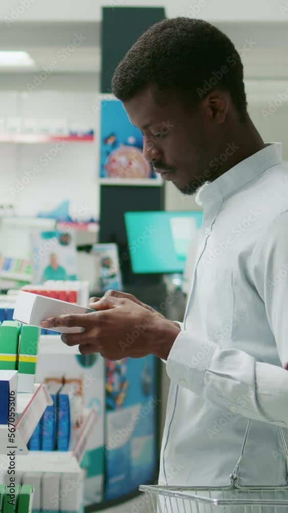 Vertical video: Male client reading leaflet on boxes of medicine, checking healthcare products from pharmacy. Young man looking at pharmaceutics and supplements, buying prescription treatment. Vertical video: Male client reading leaflet on boxes of medicine, checking healthcare products from pharmacy. Young man looking at pharmaceutics and supplements, buying prescription treatment.