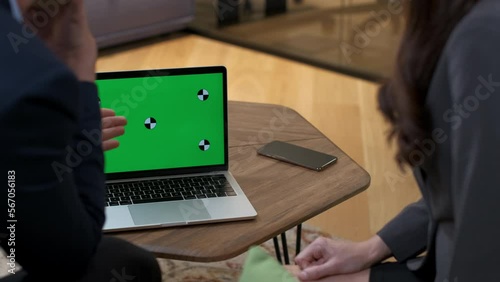 A woman puts a laptop on the table and gestures the project to the notebook. Workshop and negotiations in the office. Business meeting offline. Partners negotiate and argue. Close-up, green screen.
