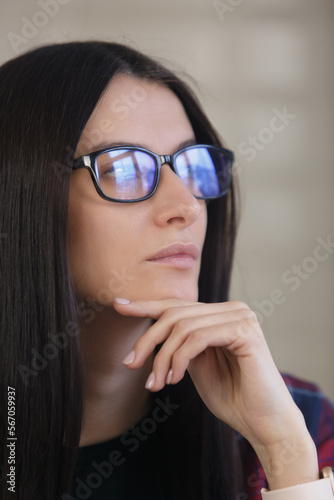 Portrait of beautiful young woman in glasses thinking about problem solution. Pensive female person looking away
