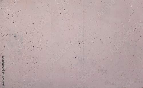 Imperfect holey porous stained concrete wall painted pink. Textured lilac background