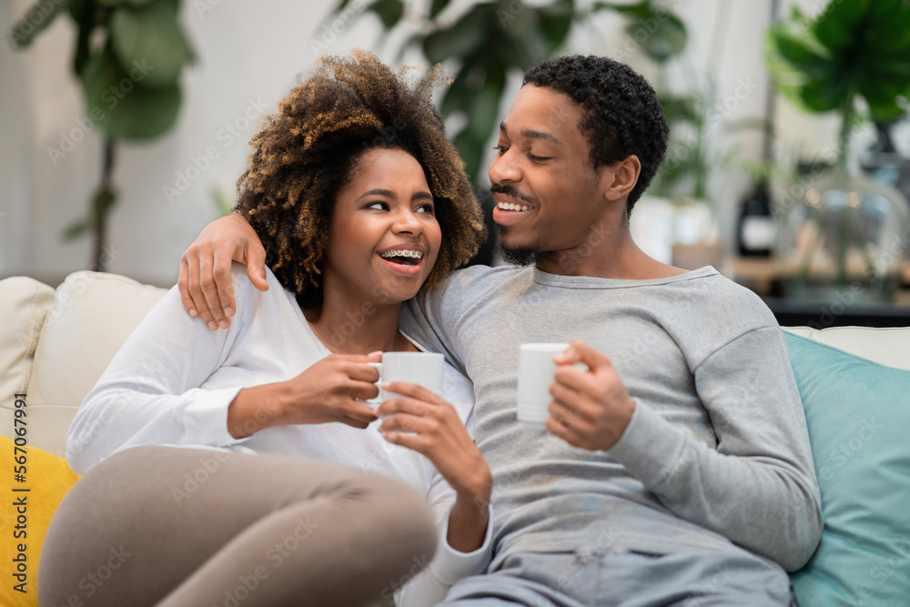 Cheerful black man and woman drinking coffee at home Cheerful black man and woman drinking coffee at home