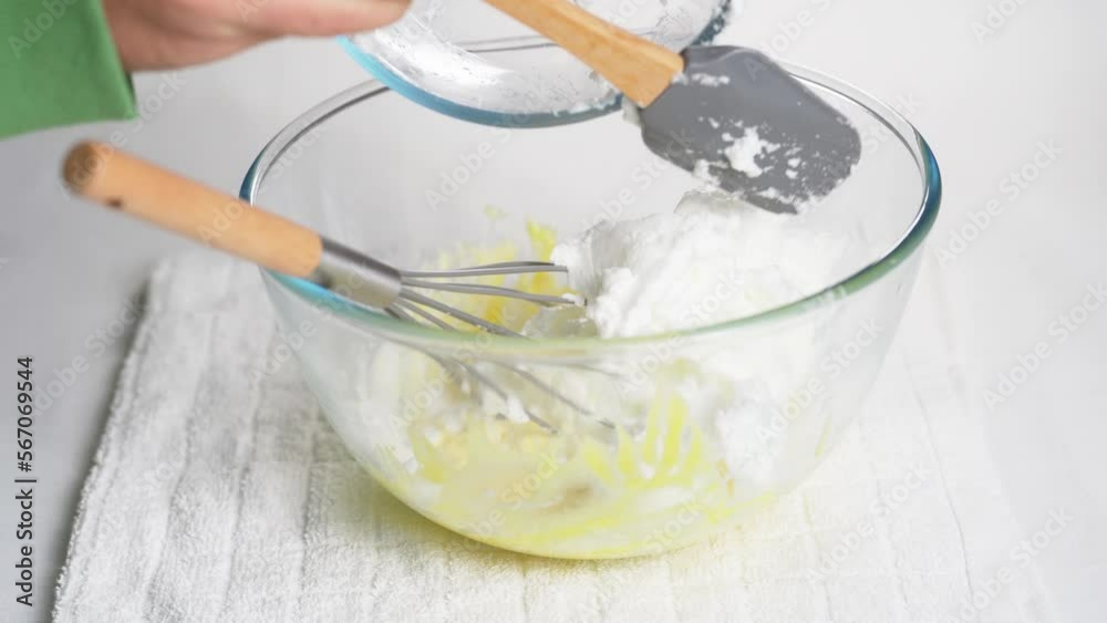 Man transfers whipped meringue egg whites to bowl with ready-made dough made from flour and egg yolk. High quality 4k footage Man transfers whipped meringue egg whites to bowl with ready-made dough made from flour and egg yolk. High quality 4k footage