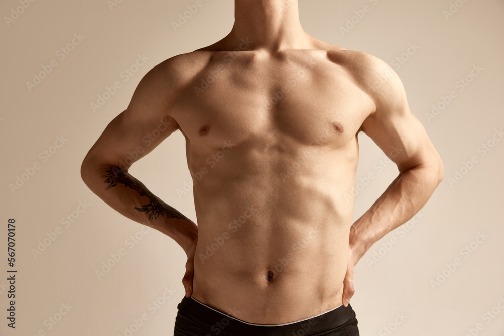 Cropped image of male relief body, breast, belly and hands over grey background. Model posing in underwear. Concept of men's health and beauty, body and skin care, fitness. Body art
