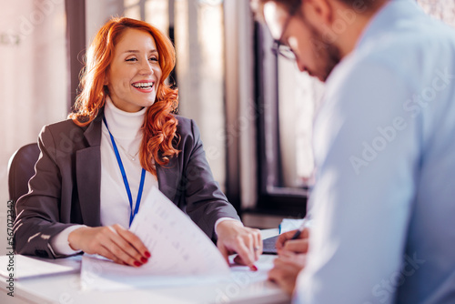 Obraz na plátne Business people man and woman sitting at the table in the office and signing the contract