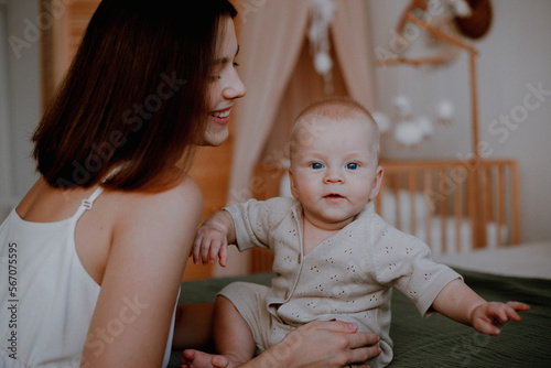 young mom playing with baby on the bed