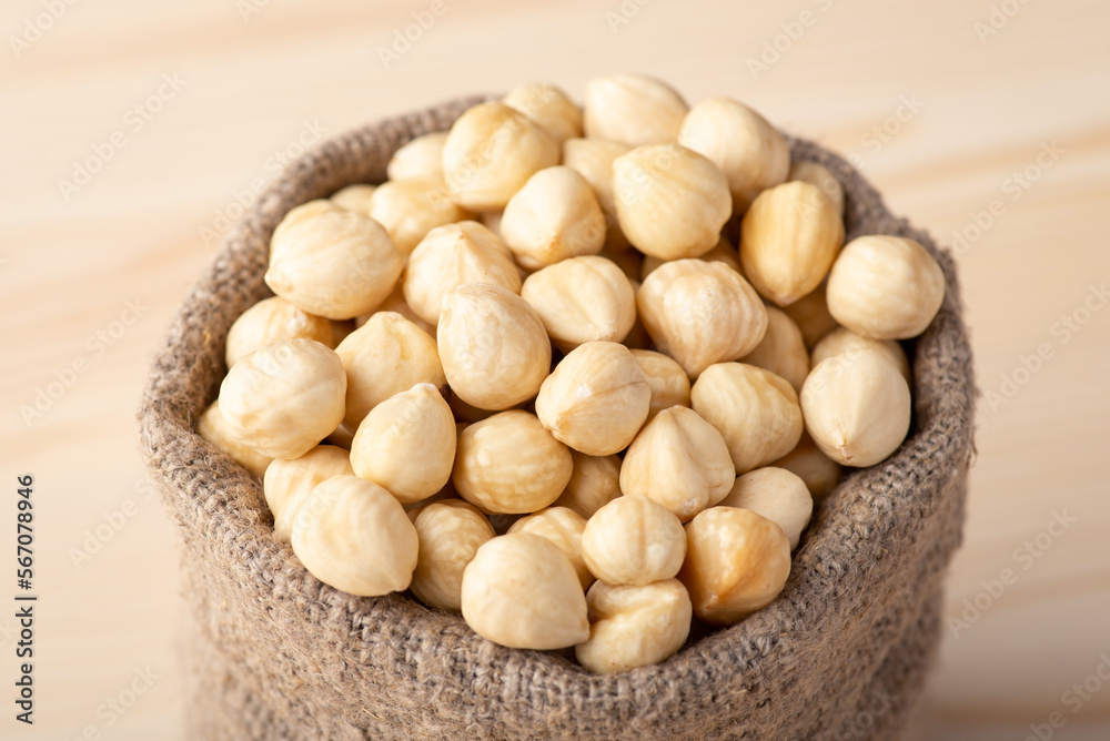 Small linen bag with hazelnuts. Close up of peeled hazelnuts in linen sack Small linen bag with hazelnuts. Close up of peeled hazelnuts in linen sack