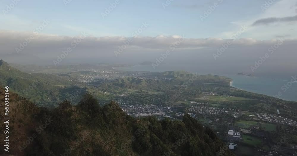 Aerial push over mountain tops in Hawaii Kai Honolulu's eastern side in the morning light revealing the city below Aerial push over mountain tops in Hawaii Kai Honolulu's eastern side in the morning light revealing the city below