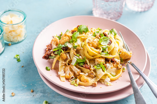Tagliatelle pasta dish with cauliflower, sun dried tomatoes, basil, chiev, walnuts and parmesan cheese